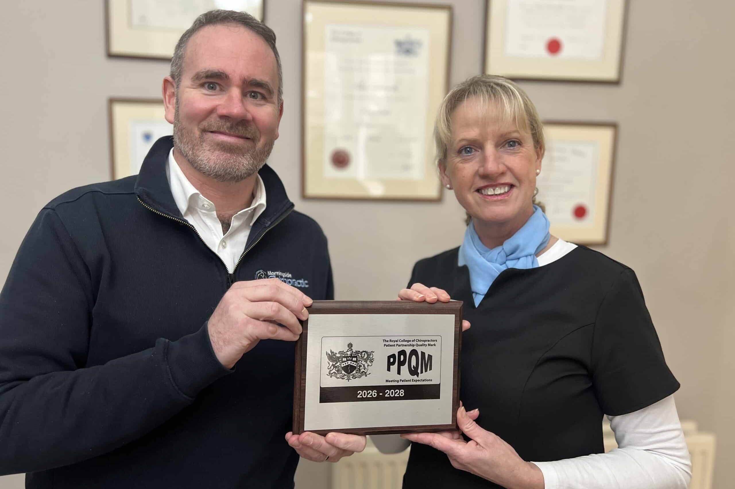 Clinic Director Alan Cavanagh and Practice Manager Dee McGlone at Morningside Chiropractic holding the Patient Partnership Quality Mark award in Edinburgh
