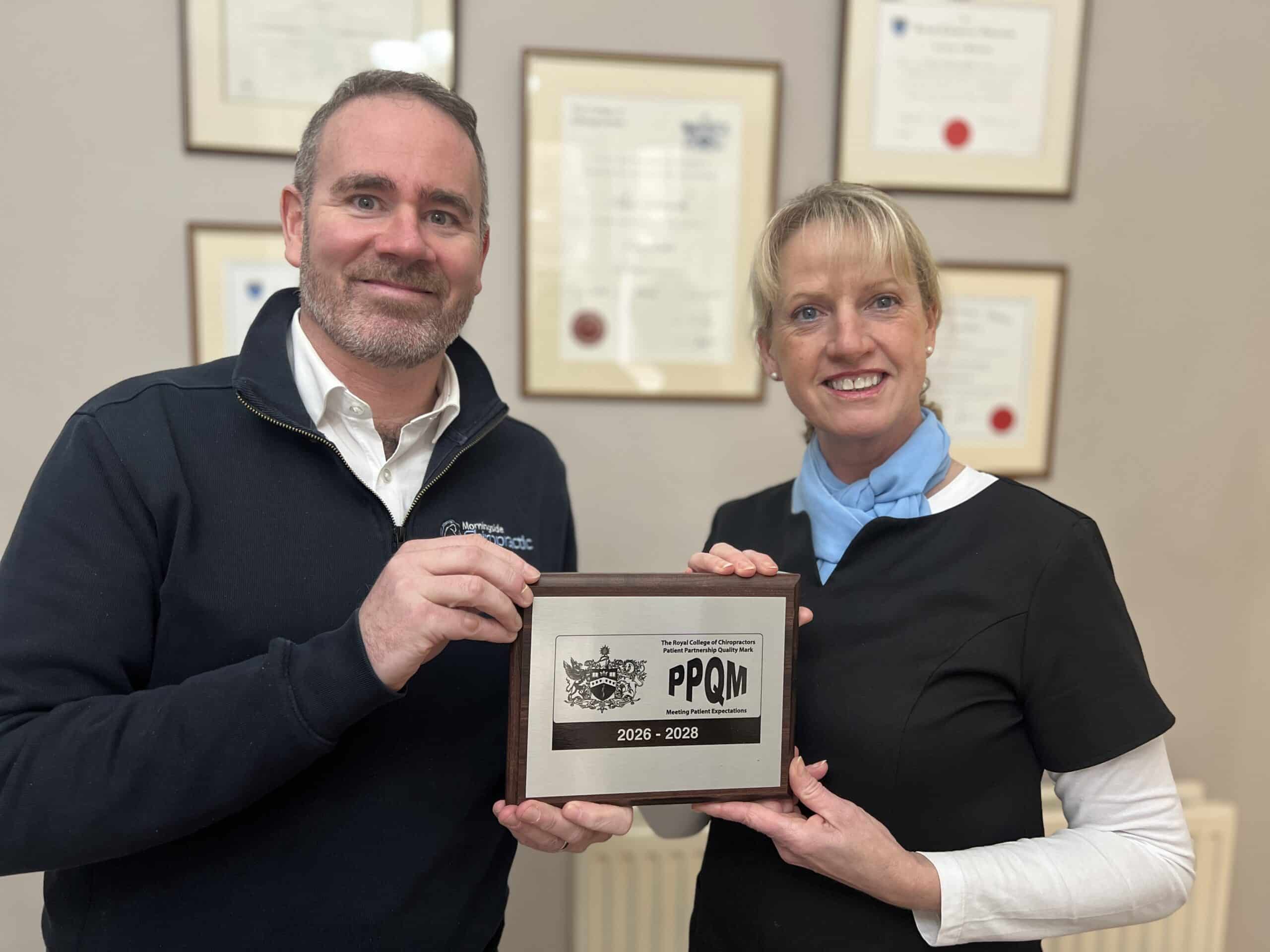 Clinic Director Alan Cavanagh and Practice Manager Dee McGlone at Morningside Chiropractic holding the Patient Partnership Quality Mark award in Edinburgh